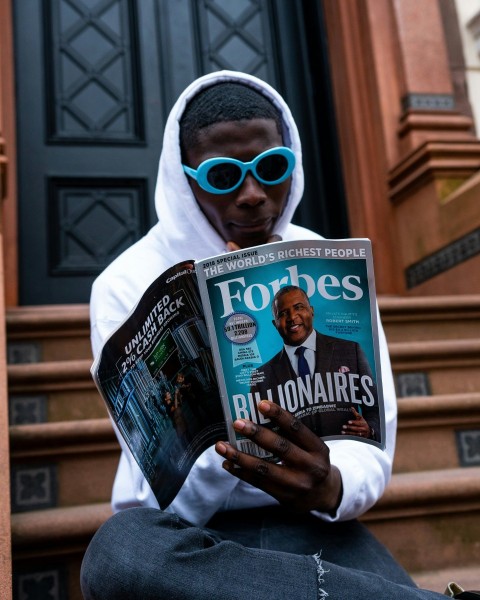 man in white long sleeve shirt holding magazine w