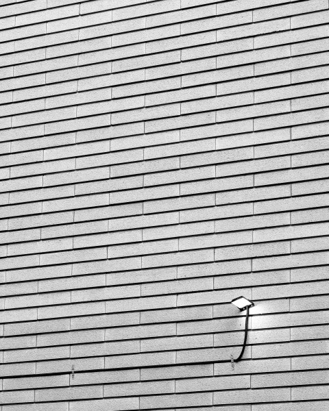 a black and white photo of a street light on the side of a building