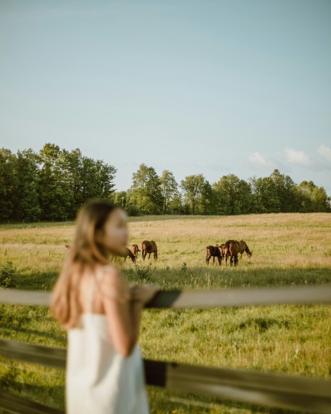 girl in white long sleeve shirt standing beside brown cow during daytime RHaQu