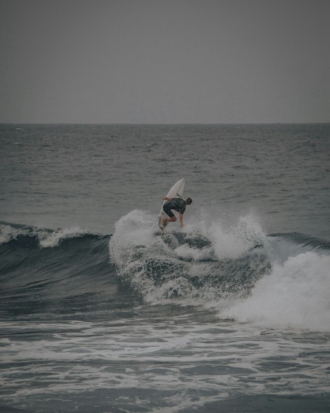 man surfing on sea waves during daytime