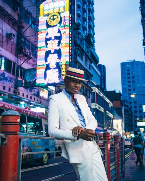 man in white coat standing on the street during daytime CmQ