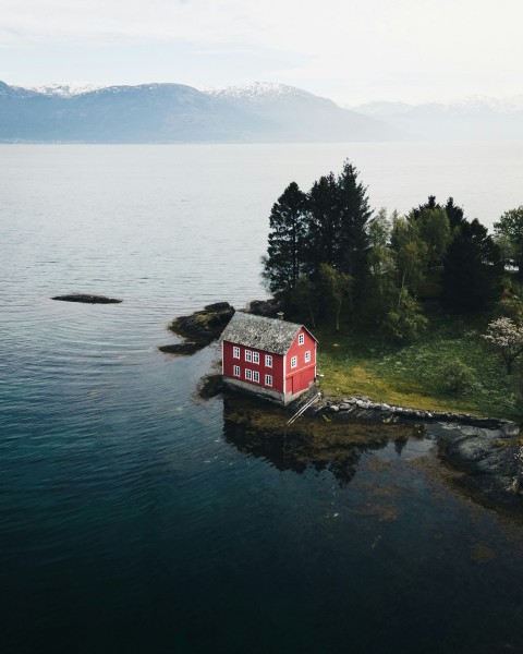 red and white house near body of water during daytime