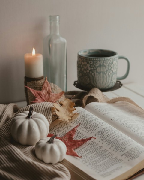 white candle beside white book page