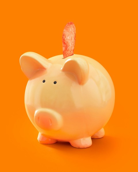 white ceramic piggy bank on orange surface