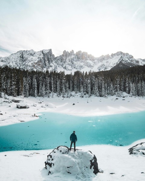 man standing on snow covered stone iqsYPka