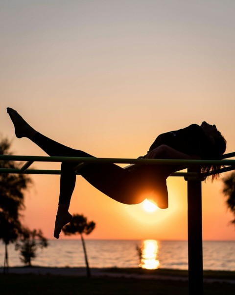 silhouette of woman doing yoga during sunset k8VDM