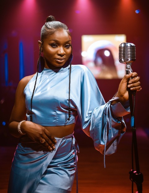 a woman holding a microphone in front of a stage