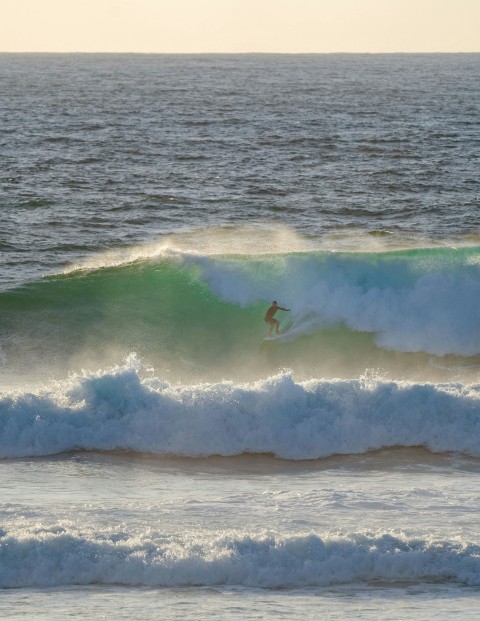 person surfing on sea waves during daytime