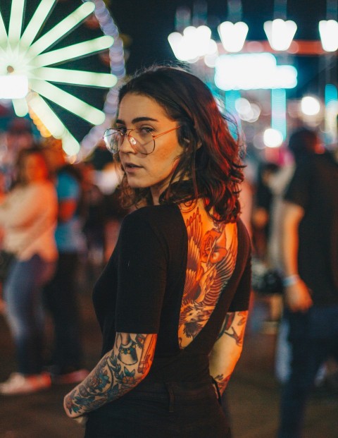 portrait photography of woman standing near ferris wheel