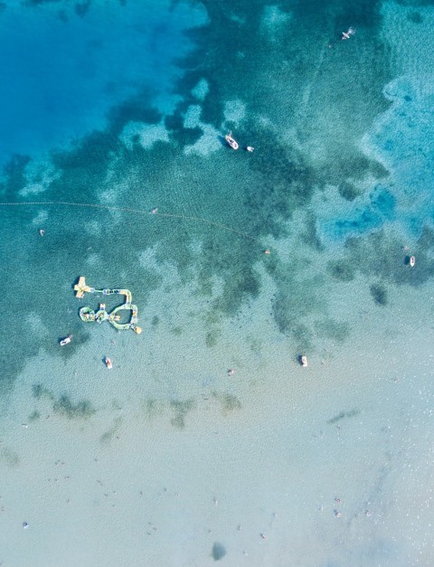 an aerial view of a beach with a kite flying in the sky