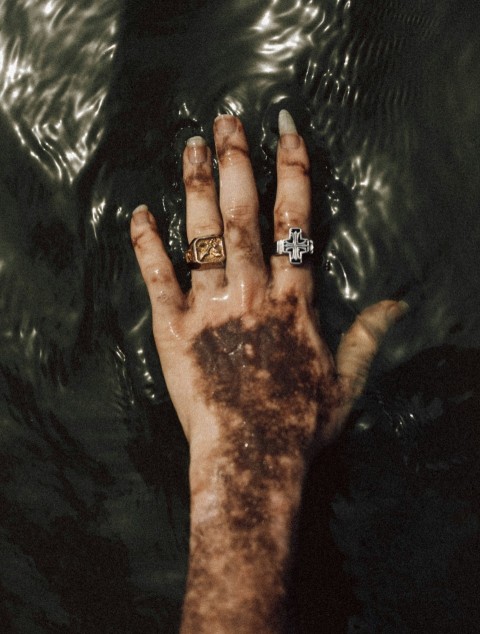 a persons hand with a ring on it in the water