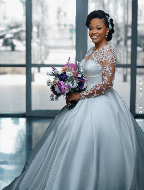 a woman in a wedding dress holding a bouquet of flowers