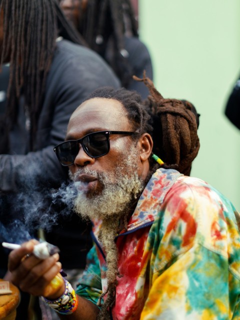 a man with dreadlocks smoking a cigarette