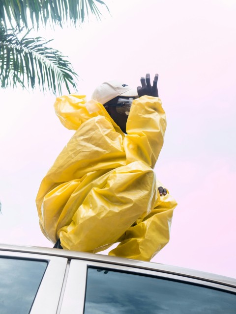 a person in a yellow raincoat on a car