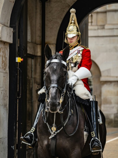 a man in a uniform riding a horse