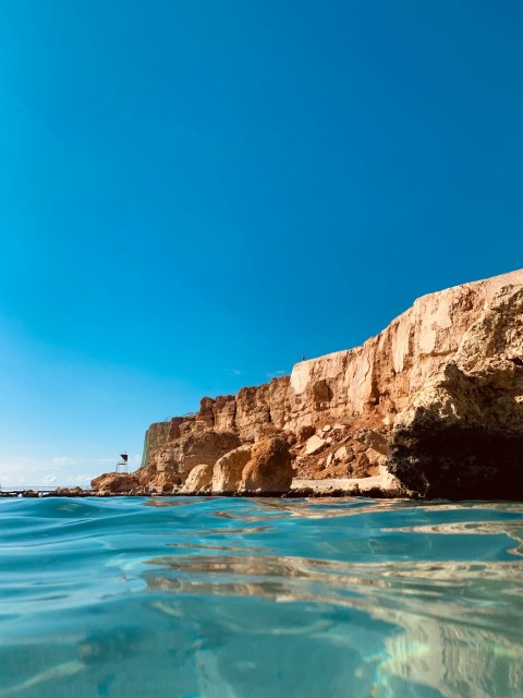 the water is crystal blue and the rocks are brown