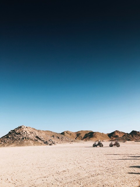 a group of four wheelers driving across a desert