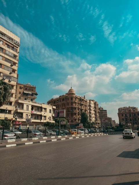 a city street with tall buildings and a blue sky