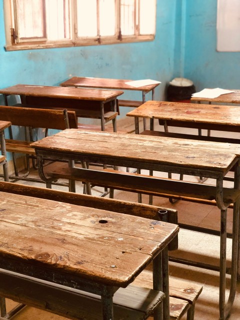 a group of wooden desks in a classroom