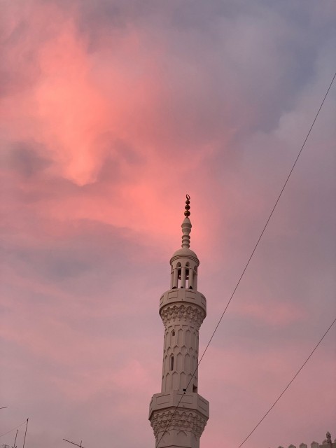 a tall white tower with a clock on its side