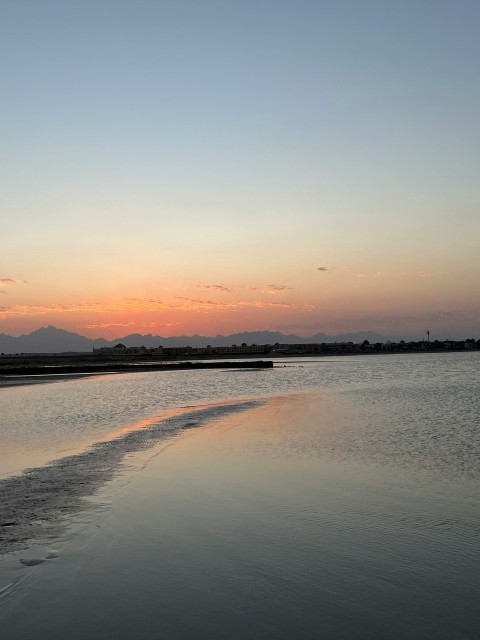 a body of water with a sunset in the background