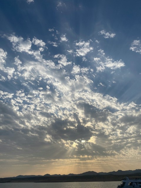 a large body of water under a cloudy sky Sj3l