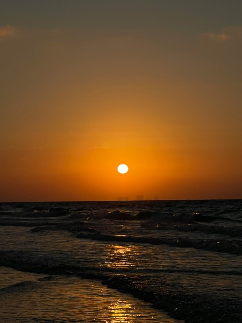 ocean waves crashing on shore during sunset