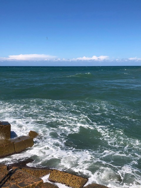 a view of the ocean from a rocky shore