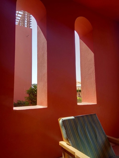 a chair sitting in front of a red wall