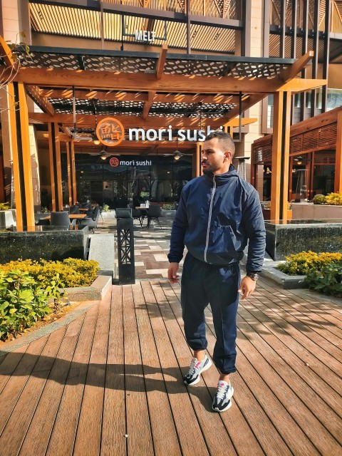 a man standing on a boardwalk in front of a hotel