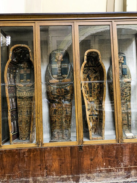 a group of carved wooden figures in a display case