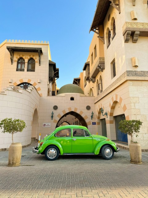 a green car parked in front of a building