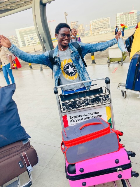 a man standing next to a cart filled with luggage