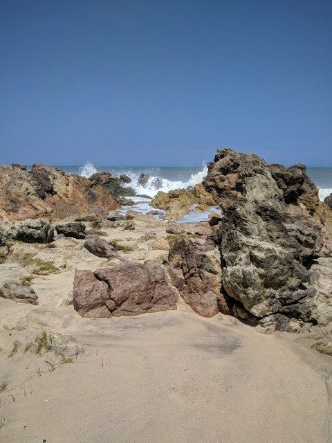 water splashing to rocky shore during day