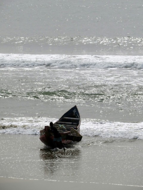 a small boat sitting on top of a sandy beach