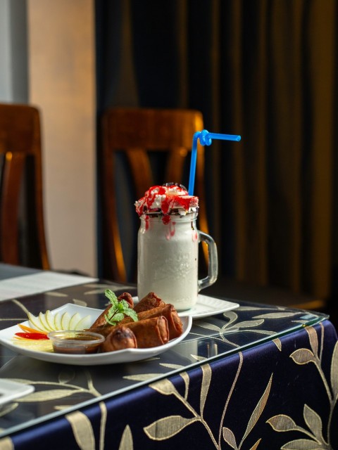 a table topped with a plate of food and a drink