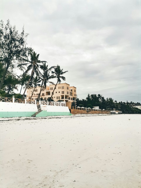 a white boat sitting on top of a sandy beach wK