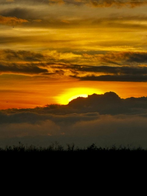 the sun is setting over the clouds in the sky