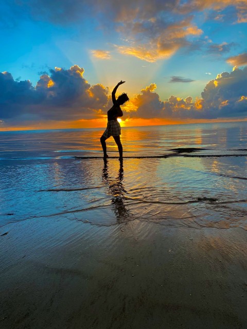 a person doing a yoga pose on the beach