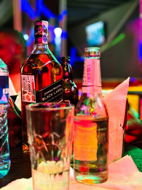 a table topped with bottles of alcohol and glasses