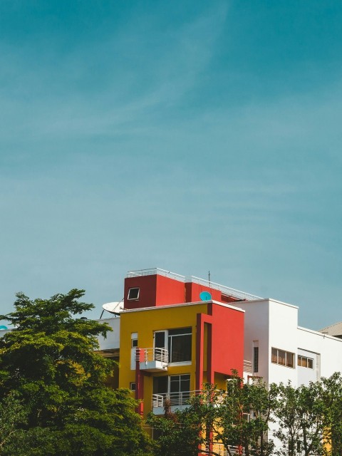 a multicolored building with trees in front of it