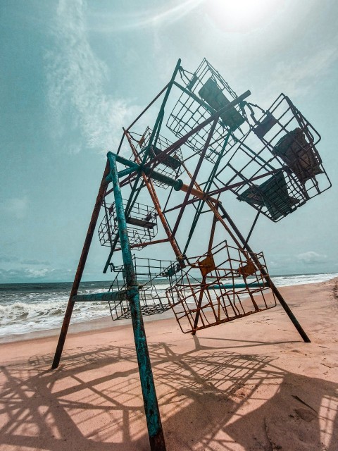 a metal structure sitting on top of a sandy beach