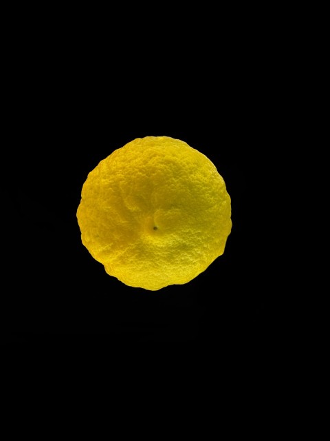 a close up of a lemon on a black background