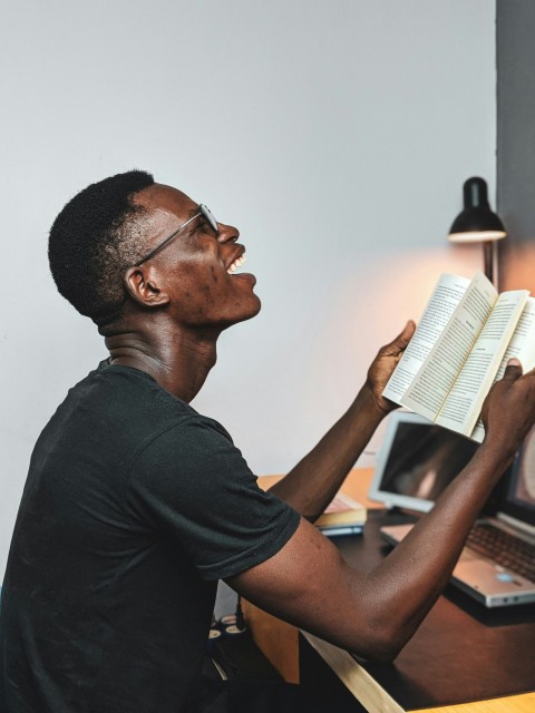 man reads book and smiles