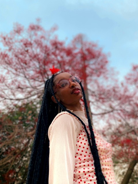 a woman with long black hair and a polka dot shirt