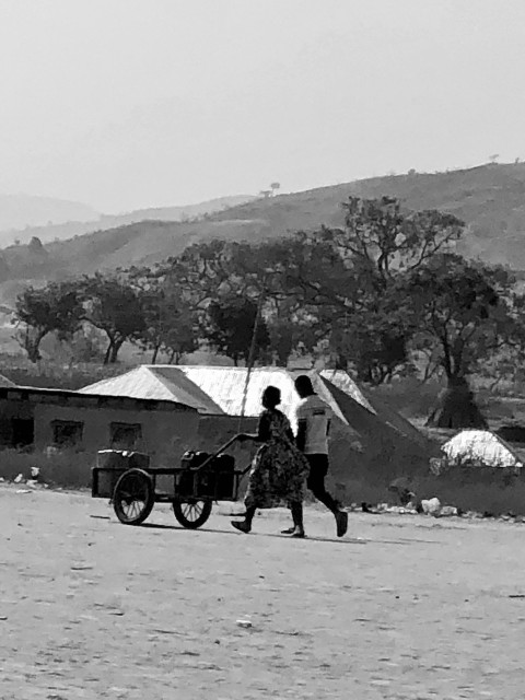 a black and white photo of two people walking