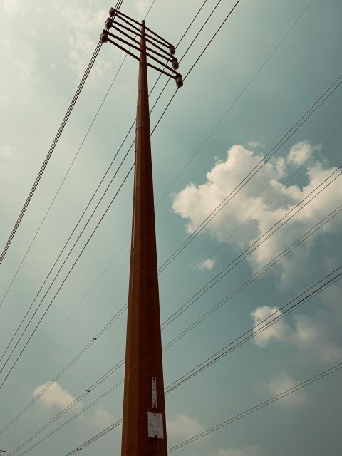 a tall tower with power lines above it