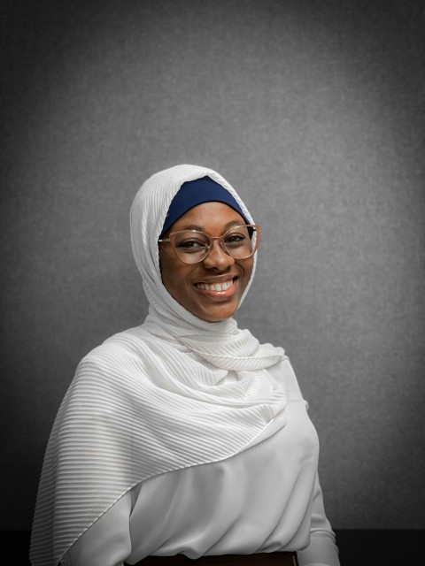 a woman wearing a headscarf and glasses d