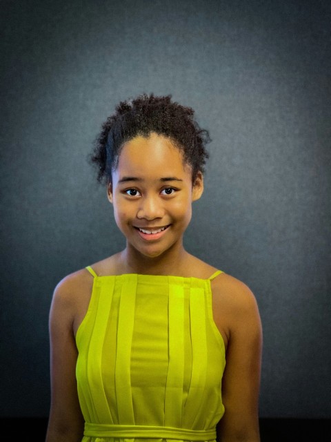 a woman in a yellow dress smiling at the camera