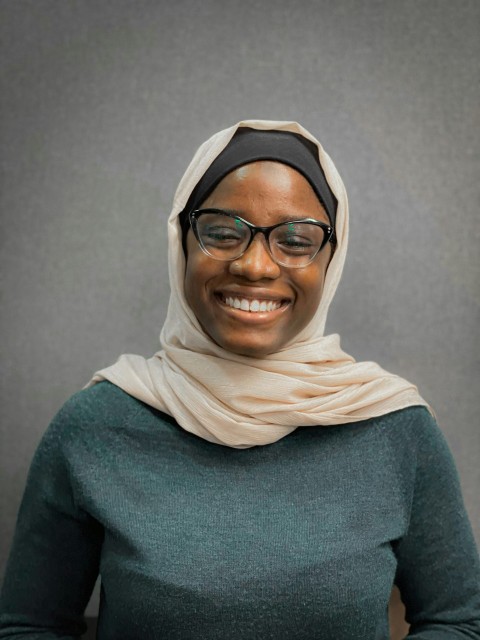 a woman wearing glasses and a headscarf fe3bItb_